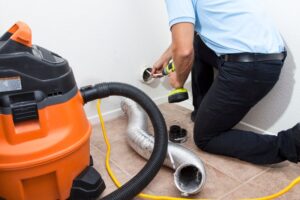 Man Cleaning Dryer Vent In Home